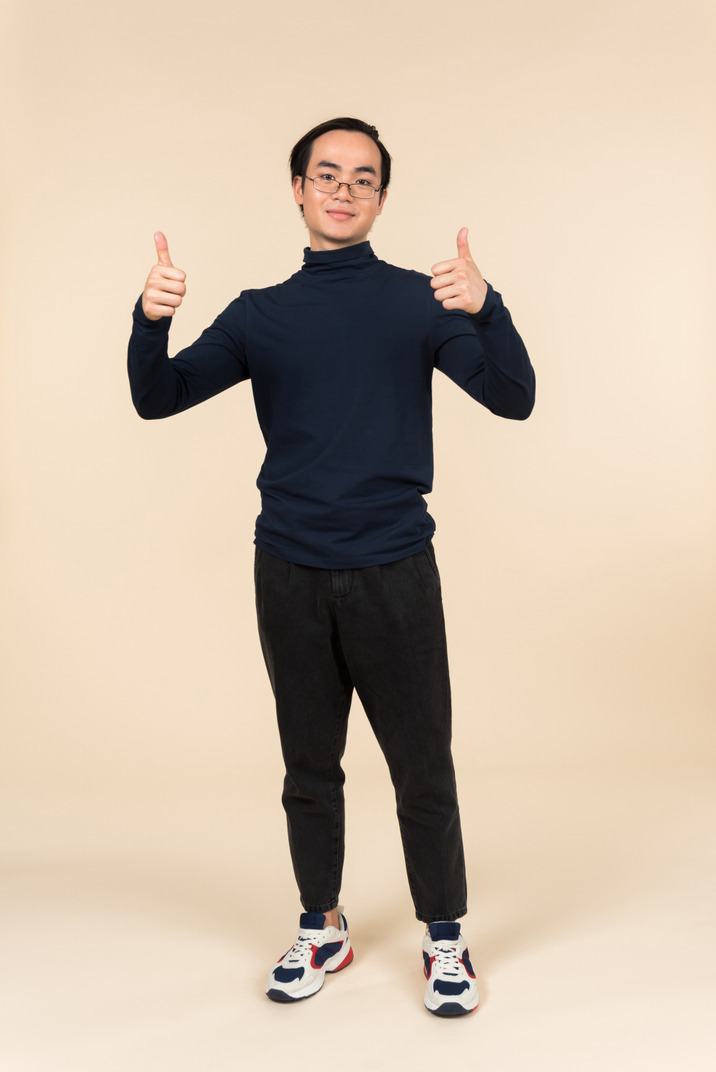 Young asian man showing thumbs up