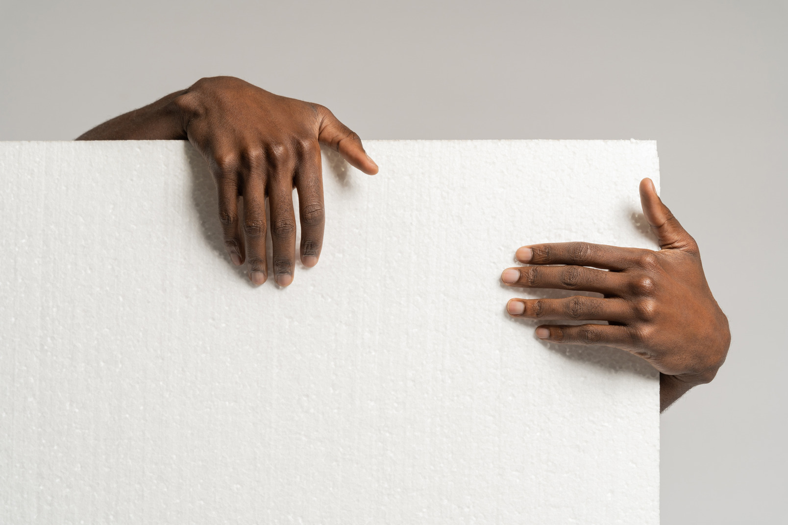 Human hands holding styrofoam board