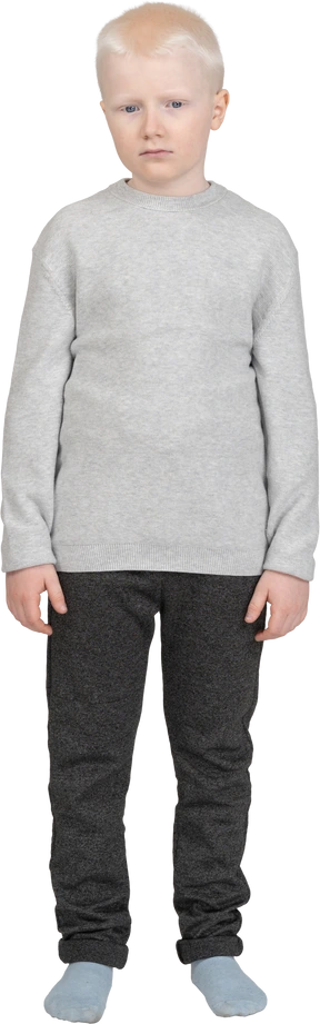 Front view of a sad kid boy standing still and looking aside
