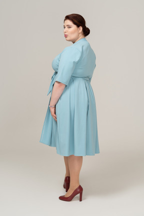 Rear view of a woman in blue dress making faces