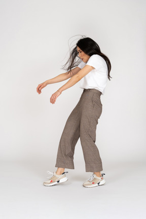 Side view of a young lady in breeches and t-shirt outstretching hands