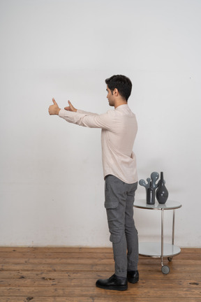 Side view of a man in suit showing thumbs up