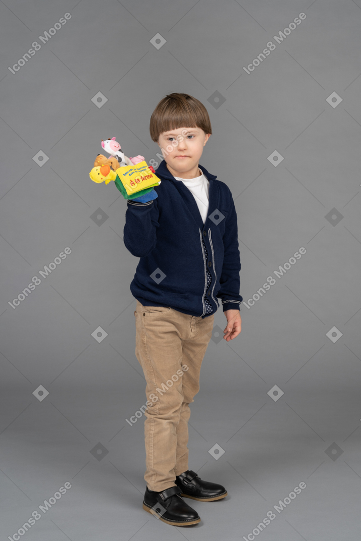 Little boy looking grumpy while holding a toy