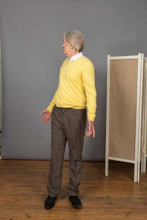 Front view of a questioning old man turning around