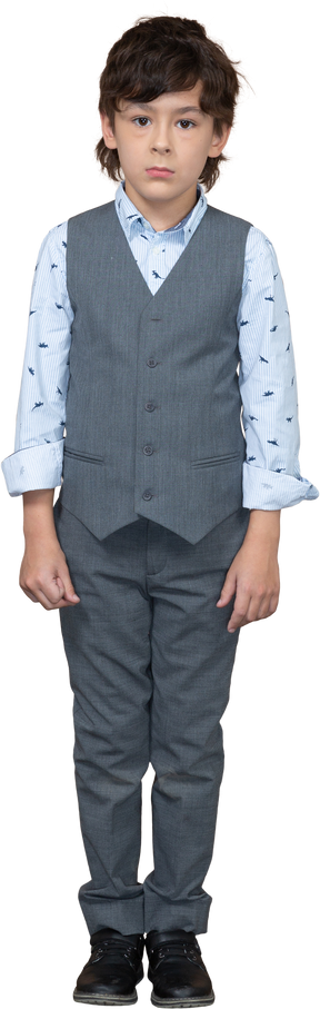 Front view of a boy in grey suit standing still and looking at camera