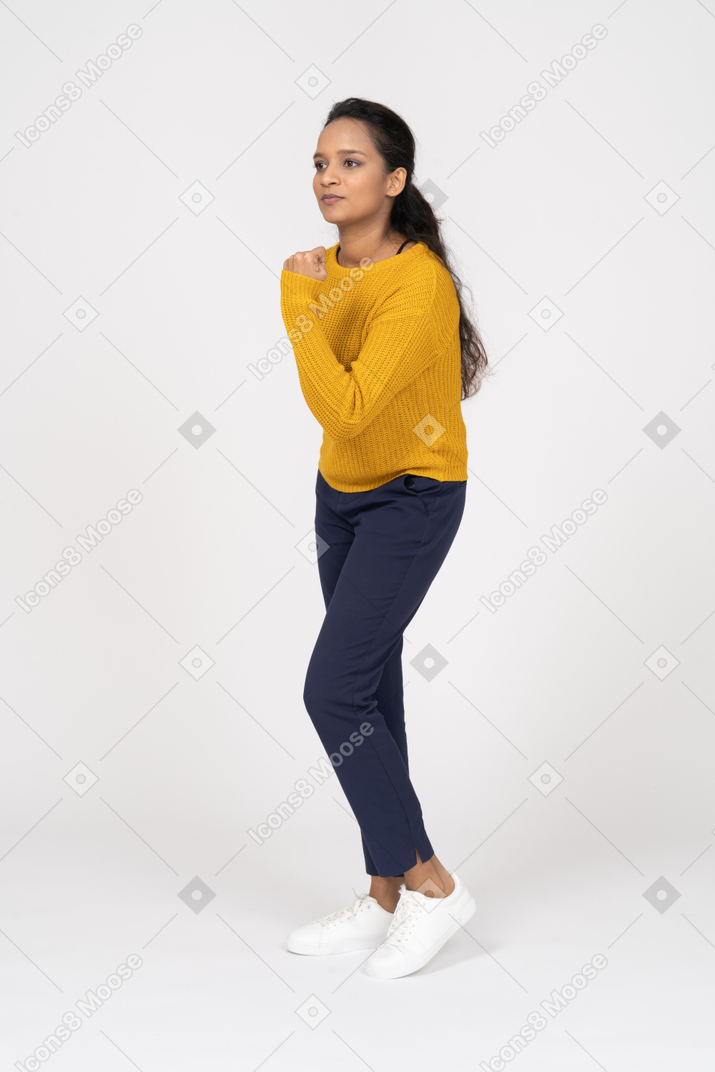 Front view of a girl in casual clothes threatening with fist