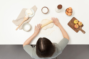 Un panettiere femmina stendere la pasta per biscotti