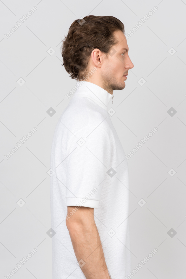 흰색 폴로 티셔츠를 입은 젊은 남자의 옆모습
