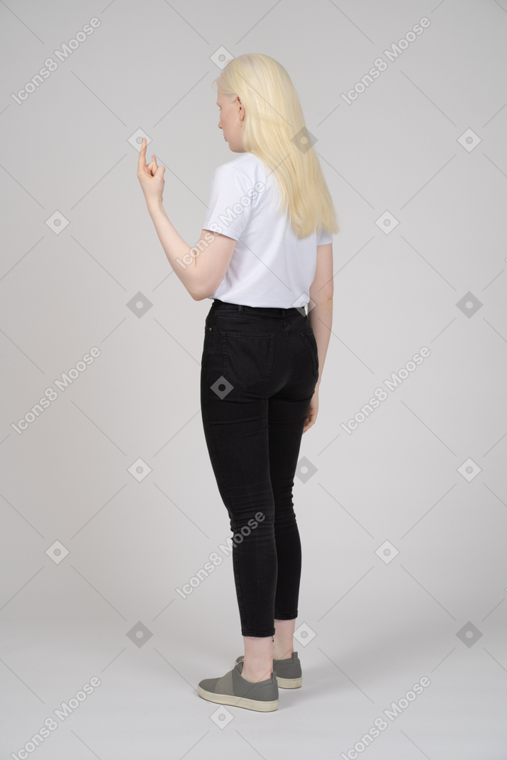Back view of a young girl standing and raising finger