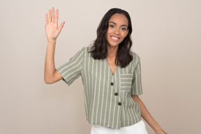 Attractive young girl salutating and waving with hand