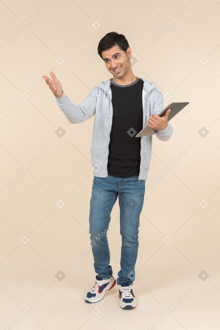 Молодой кавказский мужчина держит цифровой планшет