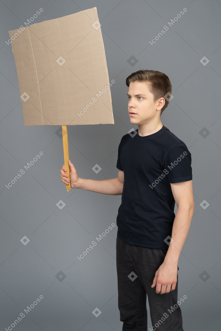 Young man holding a blank poster