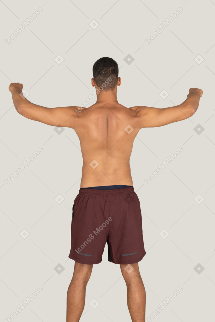 A backside view of the strong sunburnt man holding his hands up