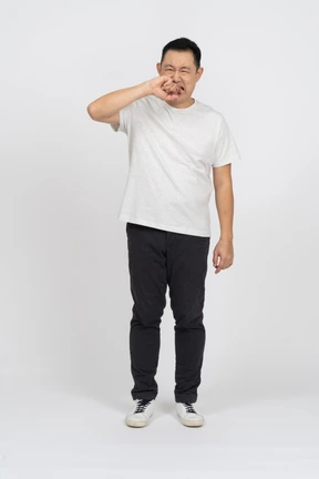 Front view of a man suffering from pain and biting finger