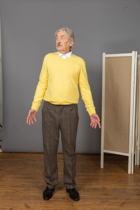 Front view of a questioning old man turning his head