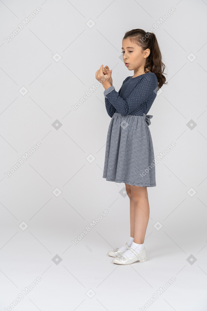 一个女孩检查手指和指甲的四分之三视图