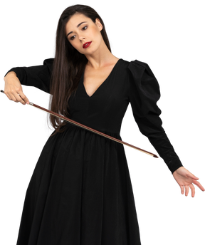 Vista frontale di una giovane donna in abito nero che tiene il fiocco