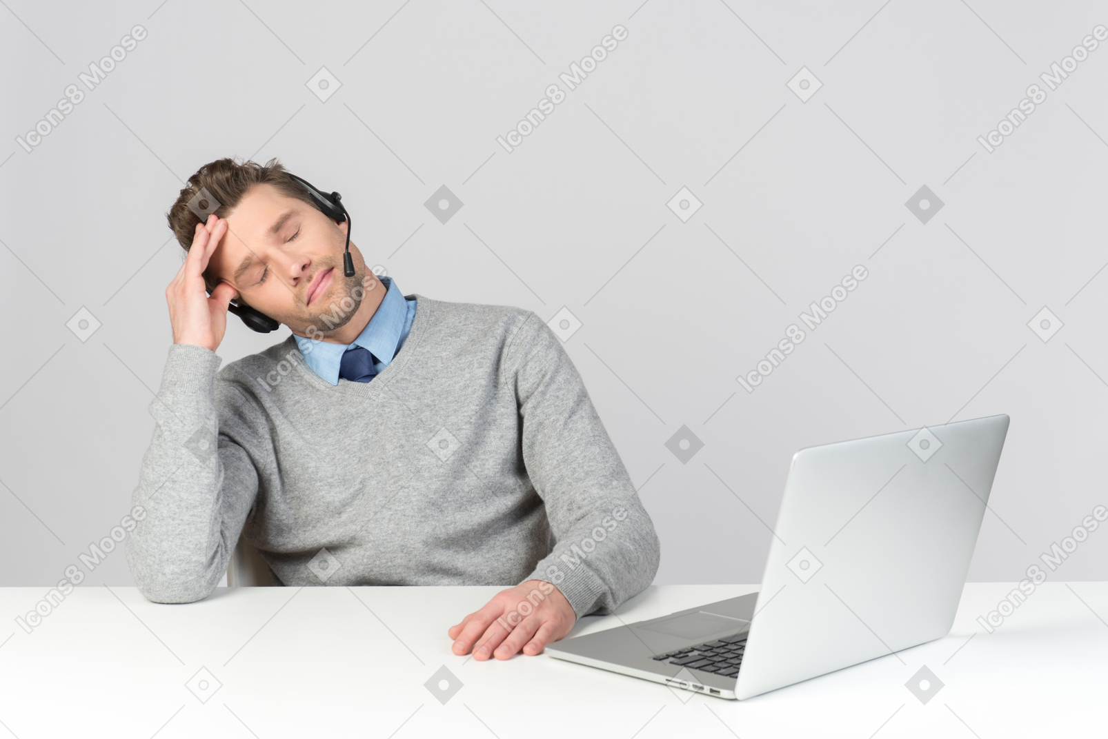 Call center agent sitting at work place and touching head