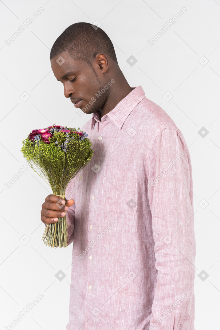 Good looking young man with a bunch of flowers