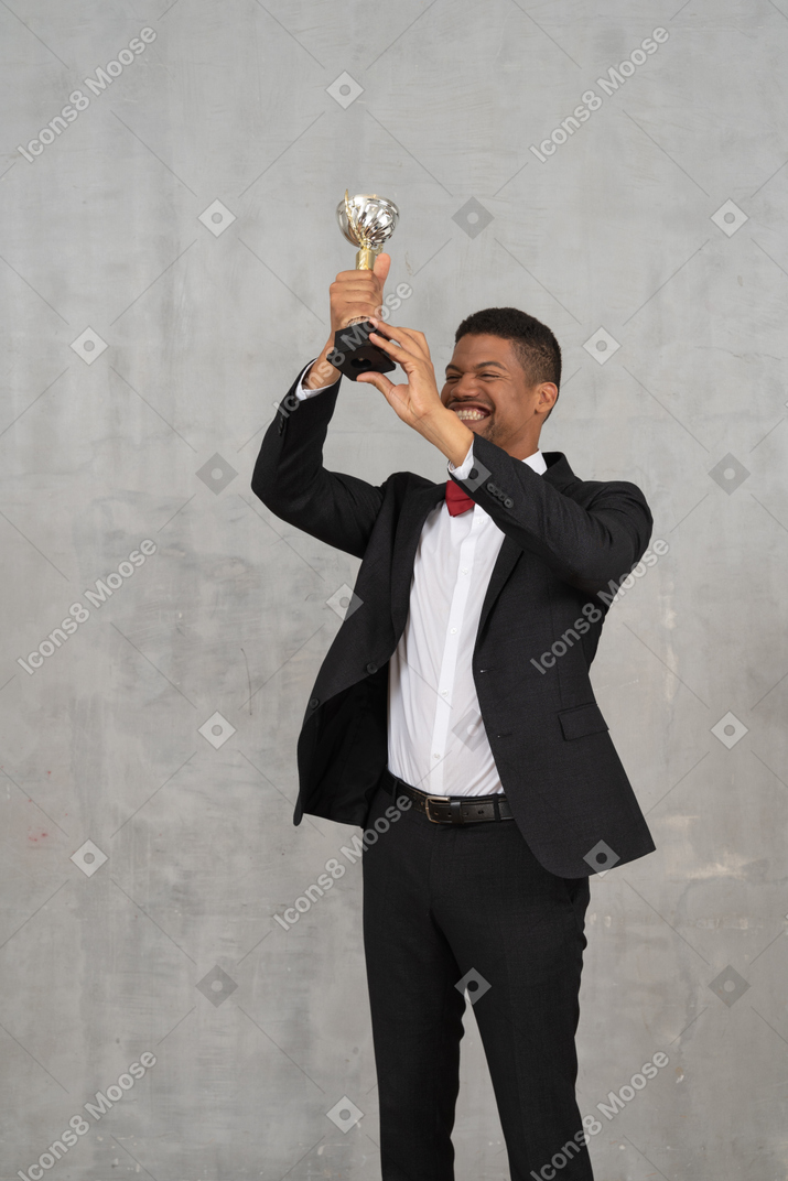 勝利を祝って賞を掲げる男性