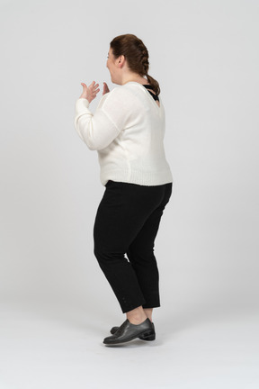 Surprised plump woman in casual clothes standing in profile