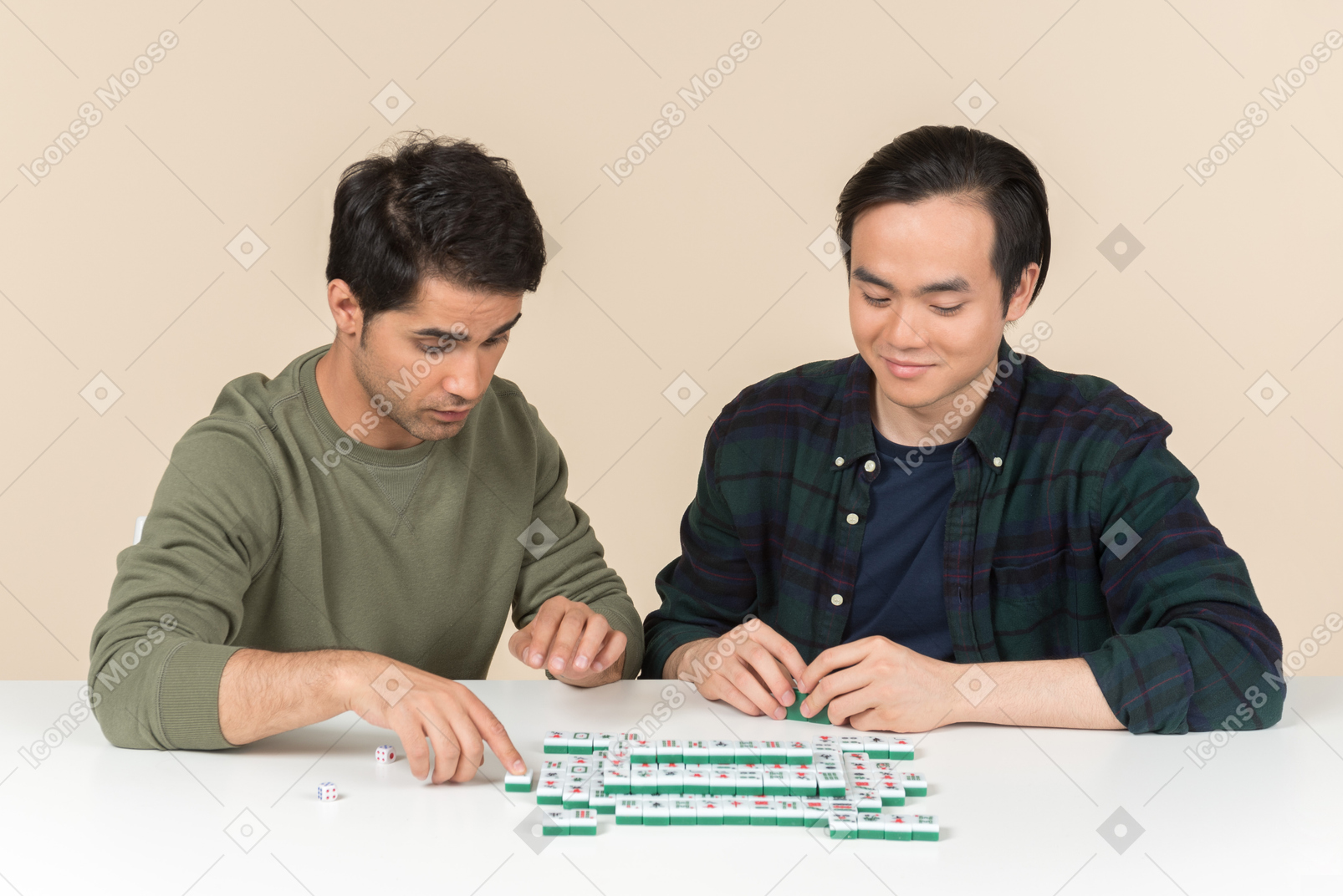 Interracial friends sitting at the table and playing board game