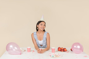 Giovane donna asiatica che regola il cono di compleanno sulla sua testa