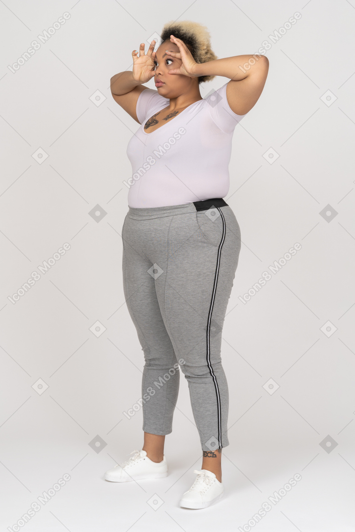 Темнокожая женщина делает жест в бинокль обеими руками
