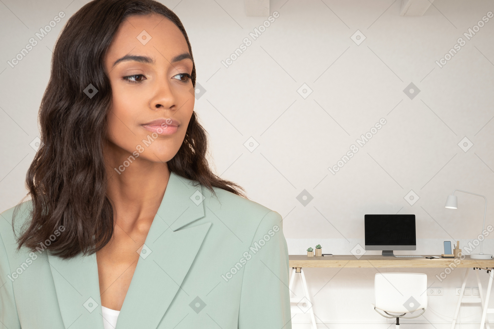 A woman in a green suit standing in front of a desk