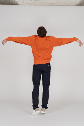 Junger mann im orange sweatshirt springen