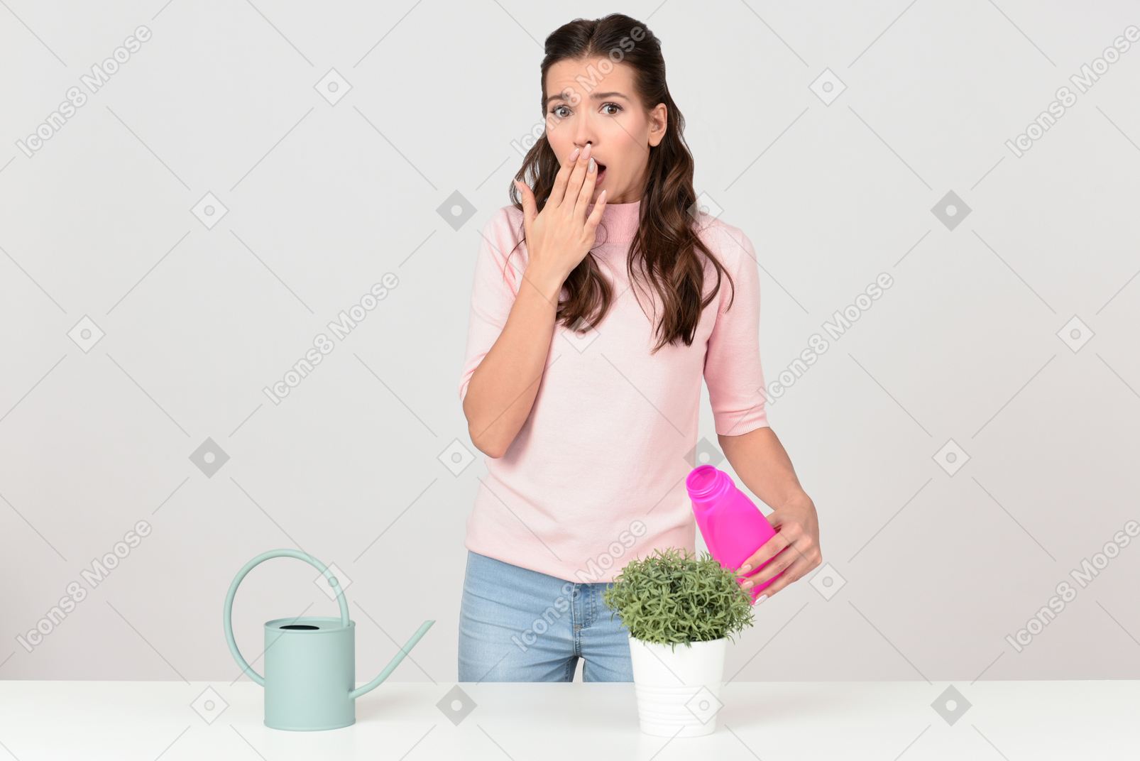 Attractive young woman gasping over mistreated houseplant