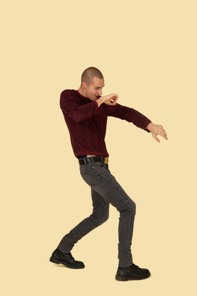 Side view of a young boxing man in red pullover