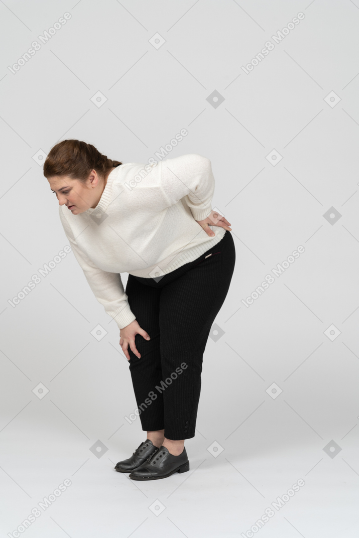 Frau in übergröße in freizeitkleidung mit schmerzen im unteren rücken