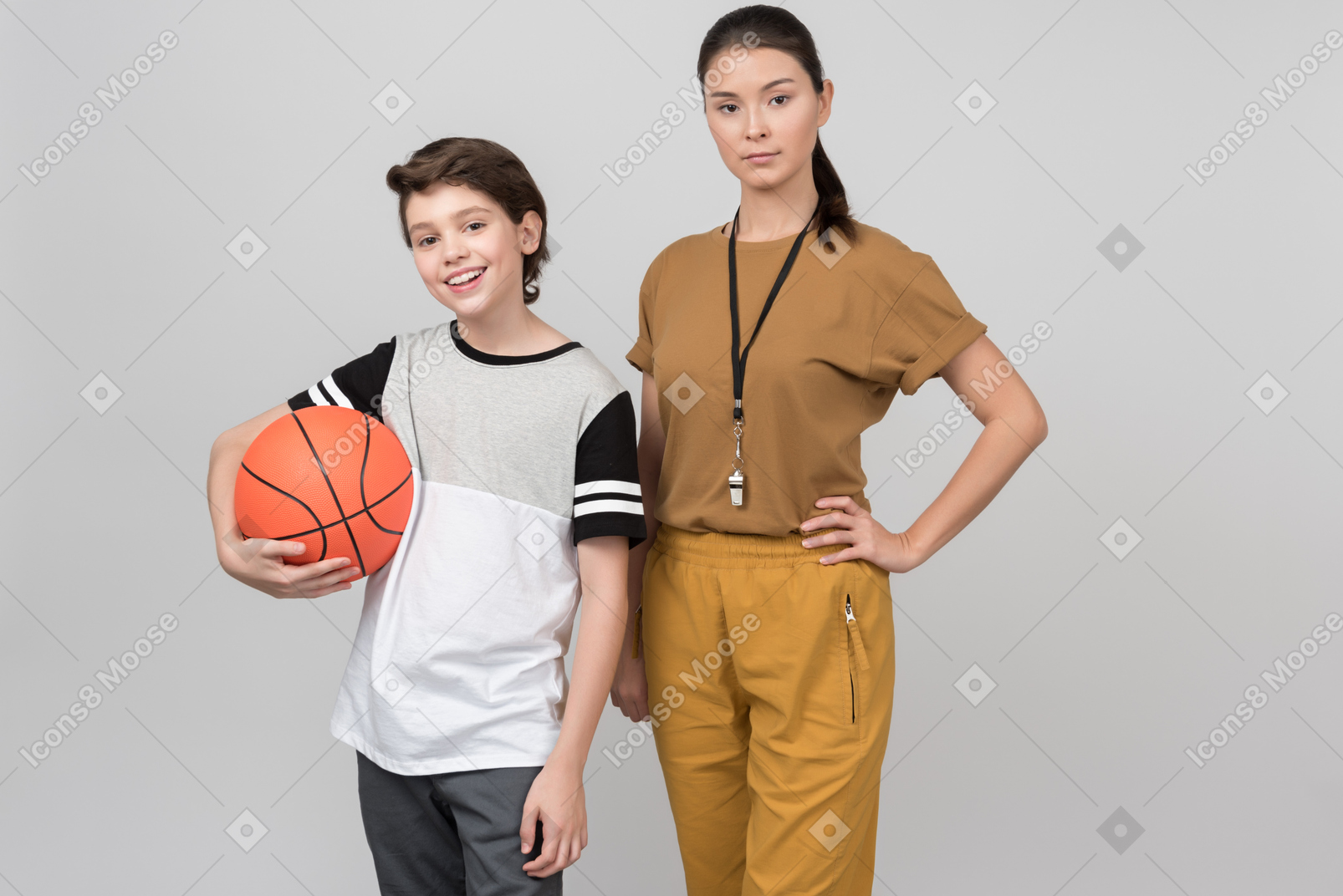 Professor de pe e seu aluno segurando uma bola de basquete