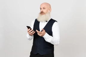 Aged man holding phone and looking bothered with something