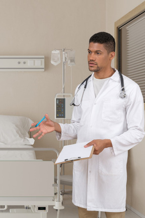 A male doctor talking to someone in a hospital room