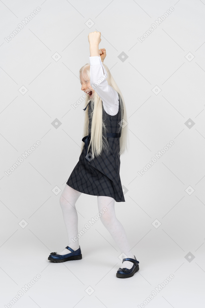 Schoolgirl holding hands up and cheering excitedly