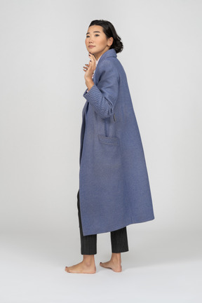 Back view of a woman in coat waving her hand