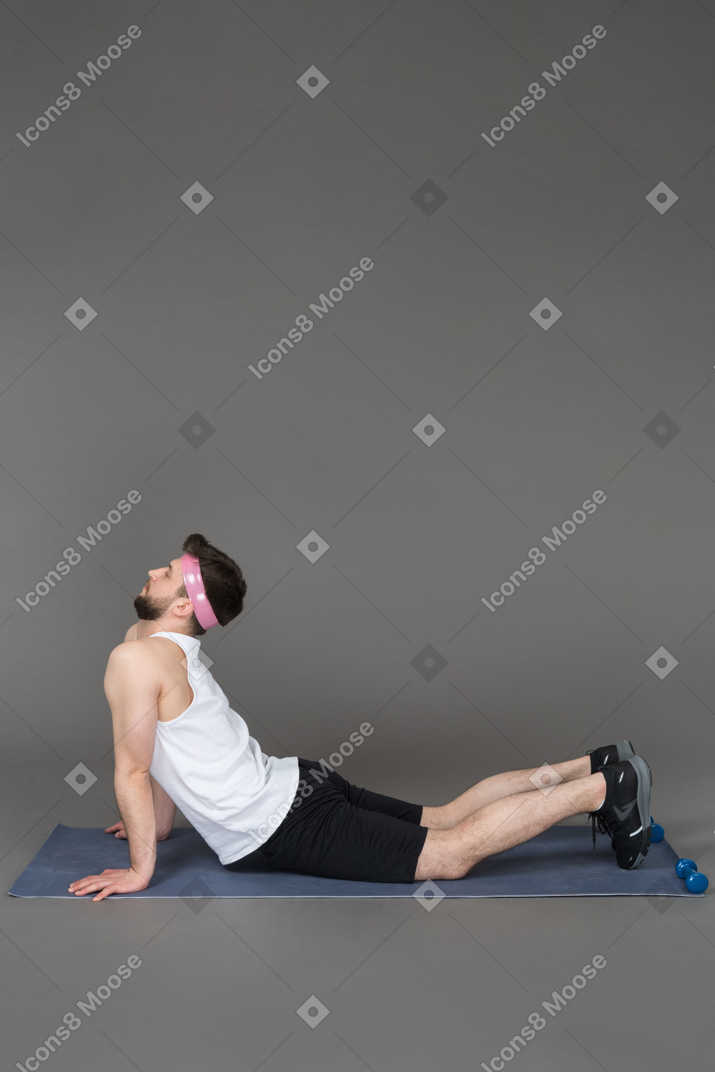 Uomo inarcandosi su un tappetino fitness