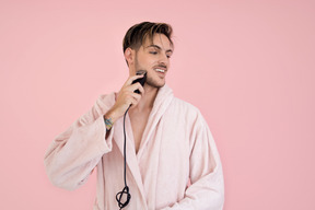 Handsome young man shaving his beard