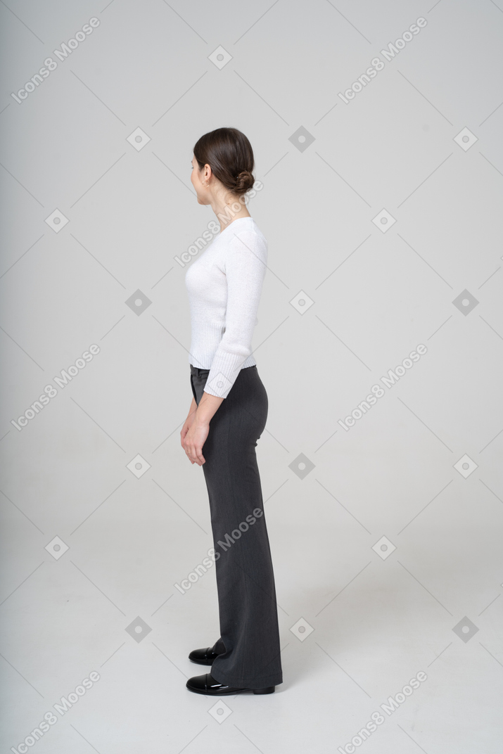 Vista lateral de uma mulher em roupas casuais de negócios olhando para longe