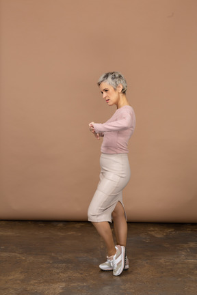 Vista lateral de uma mulher com roupas casuais mostrando os polegares para baixo
