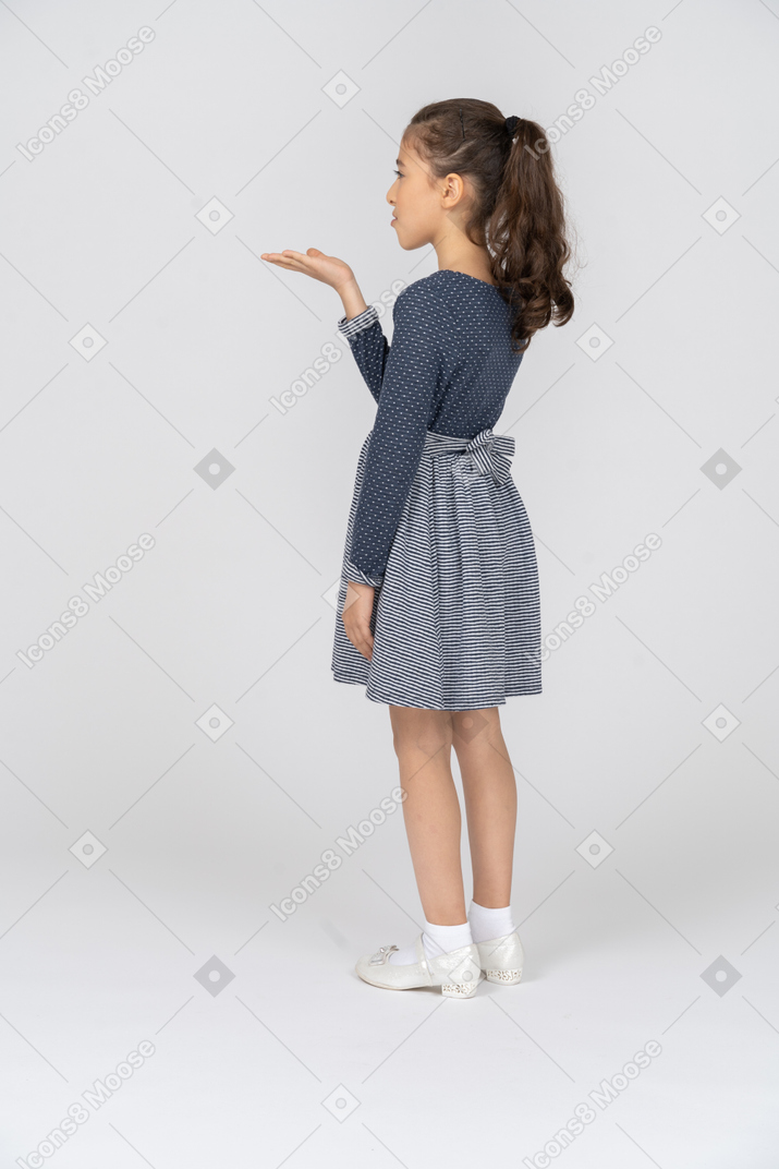 Three-quarter back view of a girl holding out her hand
