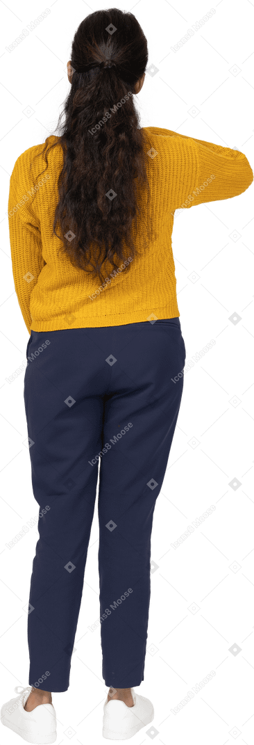 Vista posterior de una niña en ropa casual que muestra el tamaño de algo