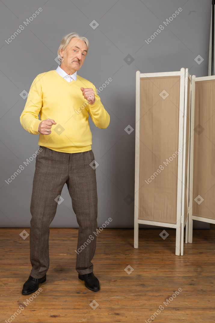 Front view of a dancing old man clenching fists
