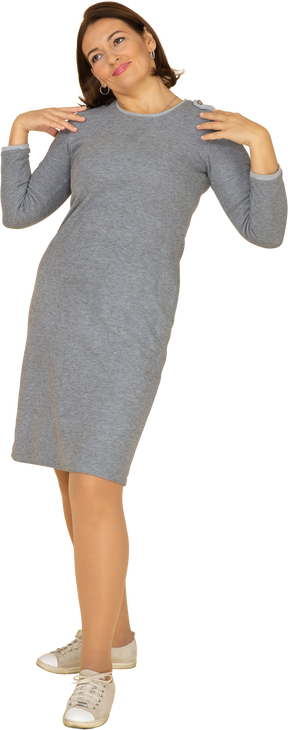 肩に手を置いて立っている灰色のドレスを着た女性の正面図