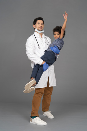 Doctor sosteniendo un niño feliz