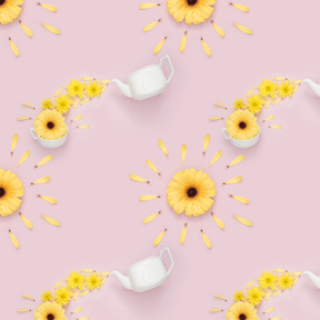 Teapot, cup and yellow flowers over pink background