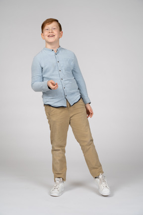 一个快乐的男孩在一条腿上保持平衡的正面图