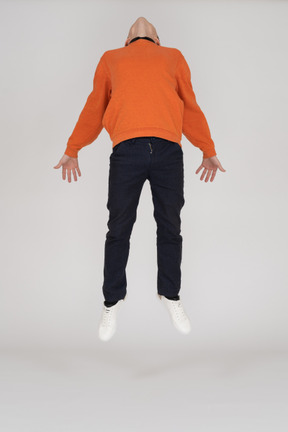 Young man in orange sweatshirt standing